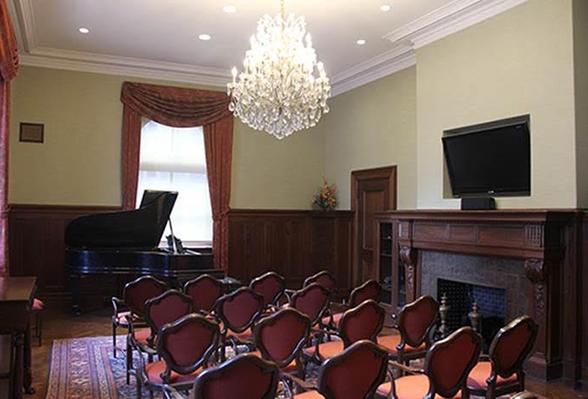 rich room with chandelier, fireplace, and grand piano